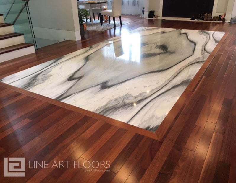 Elegant marble floor inset surrounded by polished wood flooring.