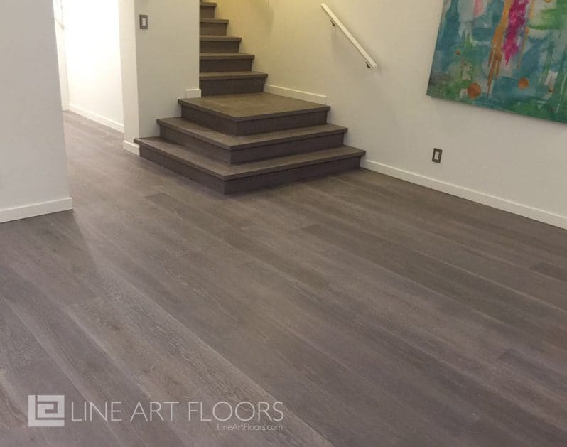 Modern staircase with sleek gray flooring and white walls.