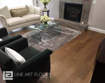 Modern living room with hardwood floors and glass coffee table.