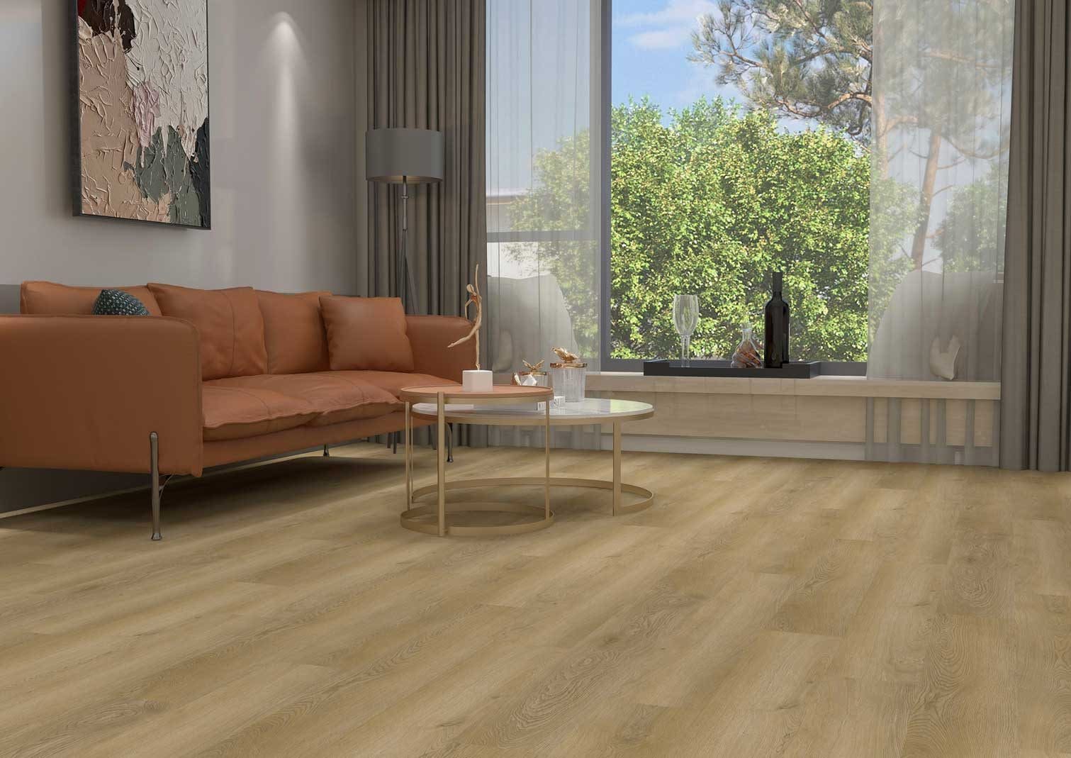 Modern living room with a tan sofa and large window overlooking greenery.